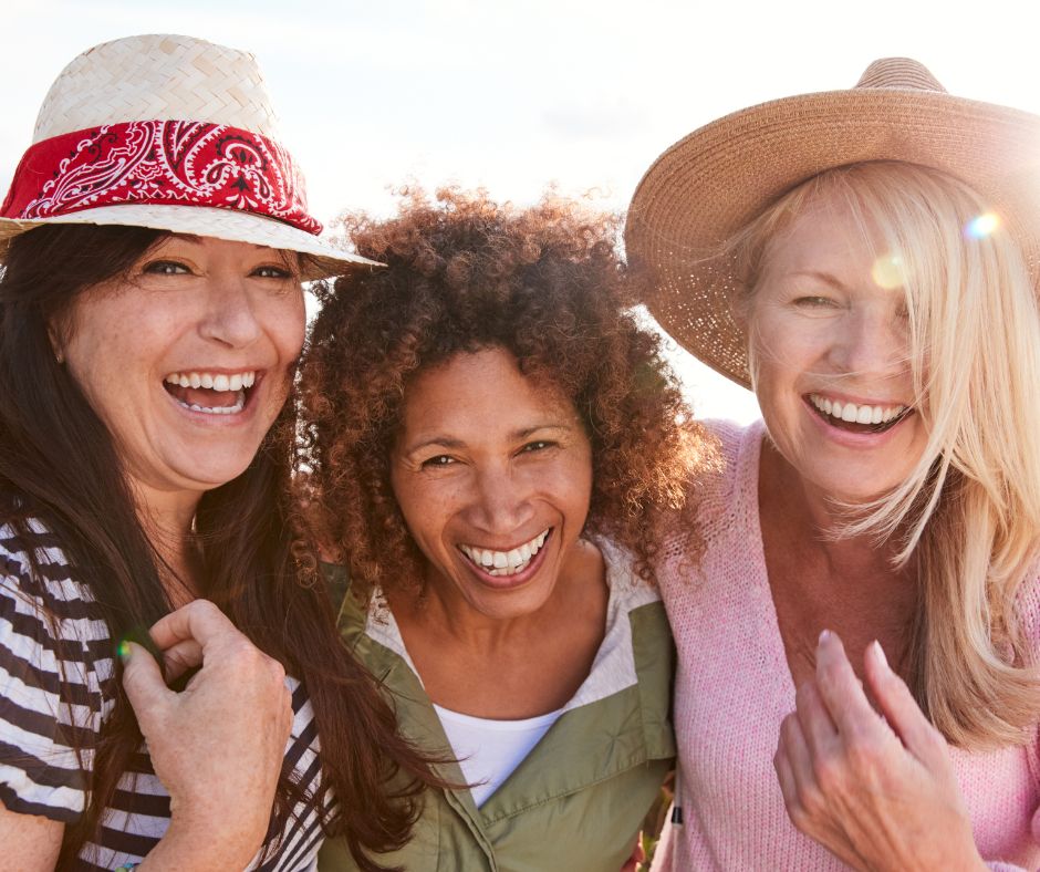 Middle-aged women smiling outside, laughing, connecting, and growing together. 